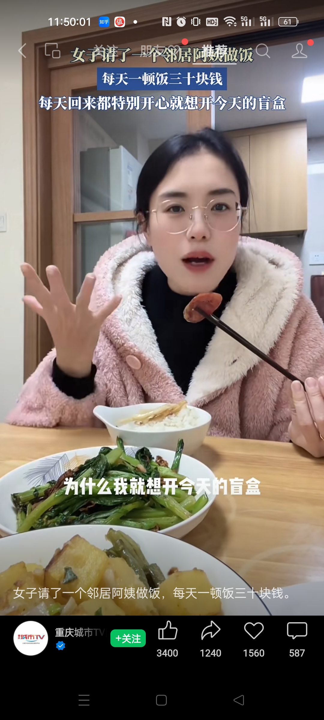 图片展示了一位女子在厨房里吃饭的场景。她穿着粉色毛绒外套,桌上摆放着两碗菜和一碗饭。上方文字介绍她请邻居阿姨做饭,每天一顿饭三十块钱,每天回来都特别开心就想开今天的盲盒。下方文字重复了“为什么我就想开今天的盲盒”。图片下方有“重庆城市TV”标识及“+关注”按钮,还有点赞、评论等互动数据。该图片与上文提到的帮爸妈找工作内容相关,展示了退休老人可能从事的简单工作之一。